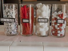 three glass jars filled with different types of candy