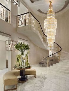 a living room filled with furniture and a spiral stair case next to a table covered in flowers