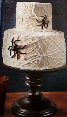 a white cake with spider decorations on it