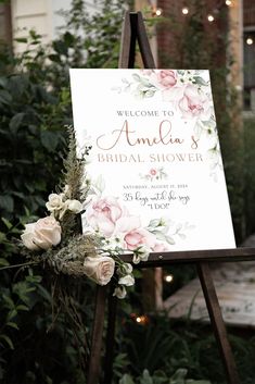 a sign with flowers and greenery on it in front of a building that says, welcome to an amazing bridal shower