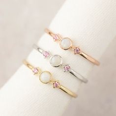 "Three stone opal and the pink sapphire ring is called \"Star and Moon Ring\", made in 100% recycled solid 14k gold featuring 3mm Australian white opal accented with pink sapphires on both sides. This unique ring is inspired by vintage art deco style ring, it is very lightweight and comfortable on your finger. Opal is known as the gem of brilliance and mystery. It is the birthstone for the month of October so it will make a unique birthday gift for October babies. Opal is a soft stone, please be White Dainty Opal Birthstone Ring, White Opal Dainty Birthstone Ring, Pink Sapphire Three Stone Jewelry, Pink Three-stone Sapphire Jewelry, Pink Sapphire Three-stone Jewelry, White Dainty Opal Ring, Dainty White Opal Ring In 14k Gold, 14k Gold White Opal Birthstone Ring, White Dainty Opal Gemstone Ring