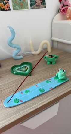 there is a green toy boat on the table next to other toys and decorations in the room