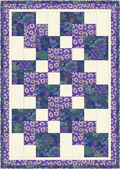 a blue and white quilt with purple flowers on the front, and green leaves on the back