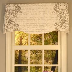 the window is decorated with an old fashioned script and valance, along with a white curtain