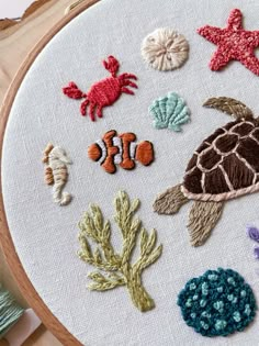 a close up of a embroidery on a hoop with sea animals and other things in it