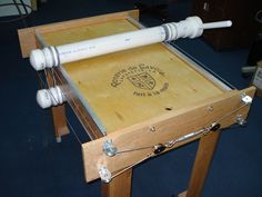 a close up of a wooden table with an object on it's side and two white pipes attached to the top