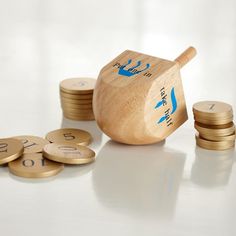 some gold coins and a wooden teapot on a white table