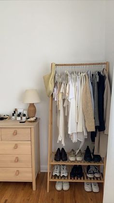 an organized closet with shoes and clothes hanging on the rack, next to a dresser