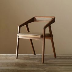 a wooden chair sitting on top of a hard wood floor next to a brown wall