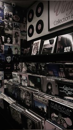 a record store with records on the shelves and posters on the wall behind them in black and white