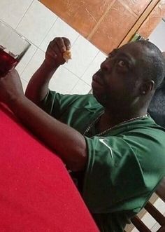 a man sitting at a table with a glass of wine in front of him and looking up