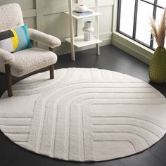 a white rug in a living room next to a chair and table with a vase on it