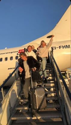 people are boarding an airplane at the airport with their luggage and bags on the stairs