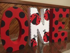 the word love is made out of wood and painted with ladybug designs on it