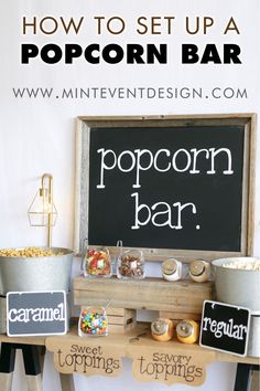 a popcorn bar is set up on an old wooden table with chalkboard and metal buckets