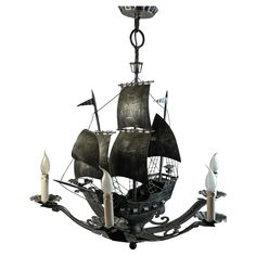 a chandelier that has a ship on it with candles in front of it