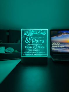 an illuminated glass plaque on a desk next to a cell phone