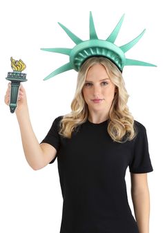 a woman wearing a statue of liberty hat and holding a green object in her hand