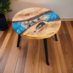 a wooden table sitting on top of a hard wood floor next to a potted plant