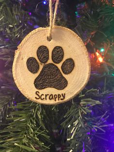 a wooden ornament with a dog's paw and the word scrappy on it