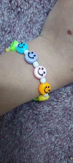 a person wearing a bracelet with smiley faces on it