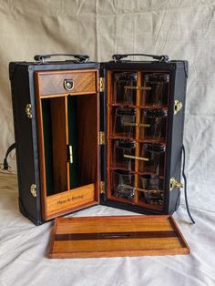 an open wooden case with many glasses inside