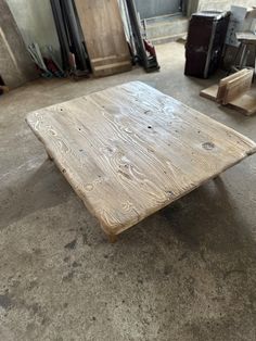 a wooden table sitting on top of a cement floor