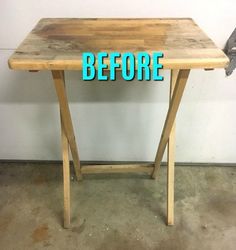 a wooden table sitting on top of a cement floor next to a metal wrench