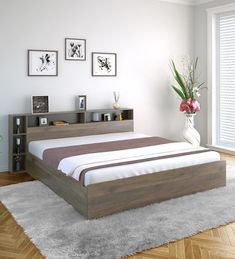 a bedroom with white walls and wood flooring has a large bed in the middle