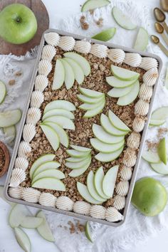 an apple pie sitting on top of a table next to sliced apples