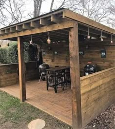 an outdoor bar with stools and tables in the middle of a wooden decked area