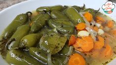 a white bowl filled with green beans and carrots