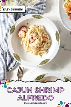 a plate with shrimp and pasta on it next to a fork, knife and napkin