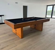 a pool table in an empty room with sliding glass doors