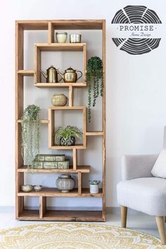 a wooden shelf filled with plants next to a white chair and wall mounted planter