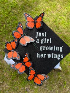 a graduation cap with butterflies on it that says, just a girl growing her wings