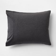 a dark gray pillow on a white wall