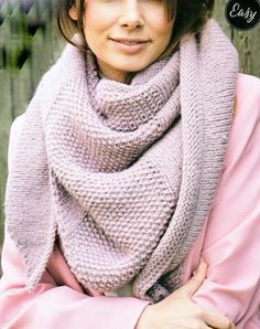 a woman wearing a knitted scarf and pink coat