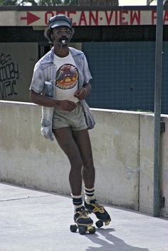 a man riding a skateboard down the side of a street next to a wall