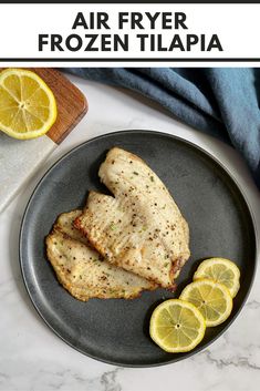 air fryer frozen tilapia on a plate with lemon wedges and slices