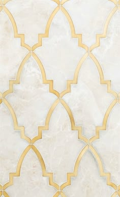 a white and gold tile wall with an intricate design