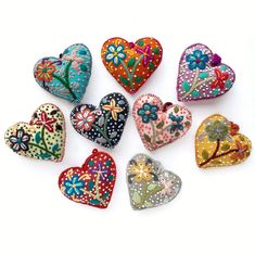 six heart shaped brooches in various colors and patterns