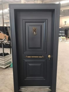 a black door with a gold handle on the front and side doors are in an empty warehouse