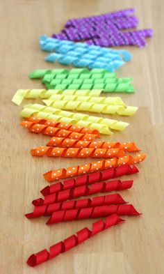 several pieces of colored paper laid out on a wooden table with scissors in the middle