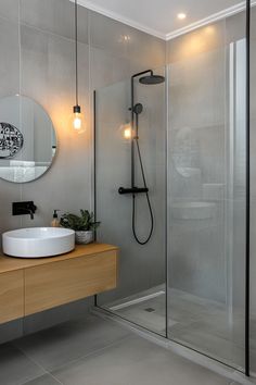 a bathroom with a sink, mirror and shower stall in it's own area