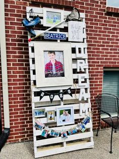 a photo frame made out of pallets with pictures on it and some words hanging from them