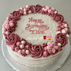 a birthday cake with pink frosting and flowers