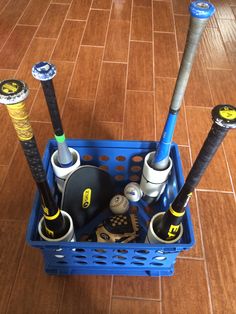 a blue basket filled with different types of baseball bats