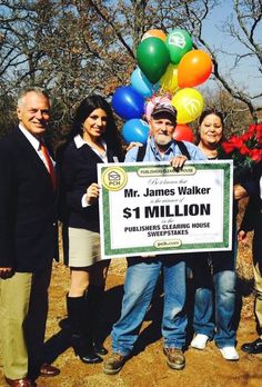 a group of people standing around each other holding a large check for $ 1 million