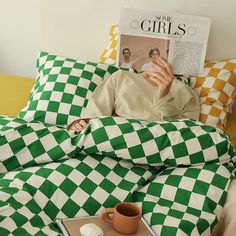 a person laying in bed reading a magazine